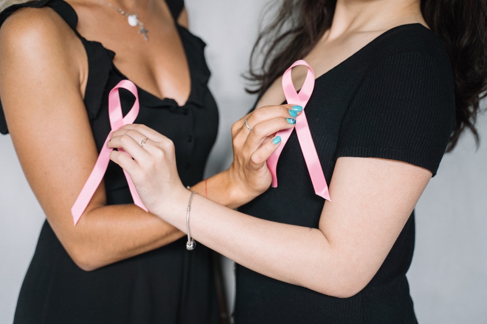 Image oif two women with pink ribbons to illustrate preventing cancer